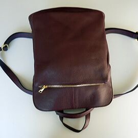Un modelo de mochila de piel de mujer y posibilidad de hacerlo en bandolera con bolsillos y de color burdeos