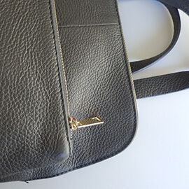 Un modelo de mochila de piel de mujer y posibilidad de hacerlo en bandolera con bolsillos y de color gris oscuro
