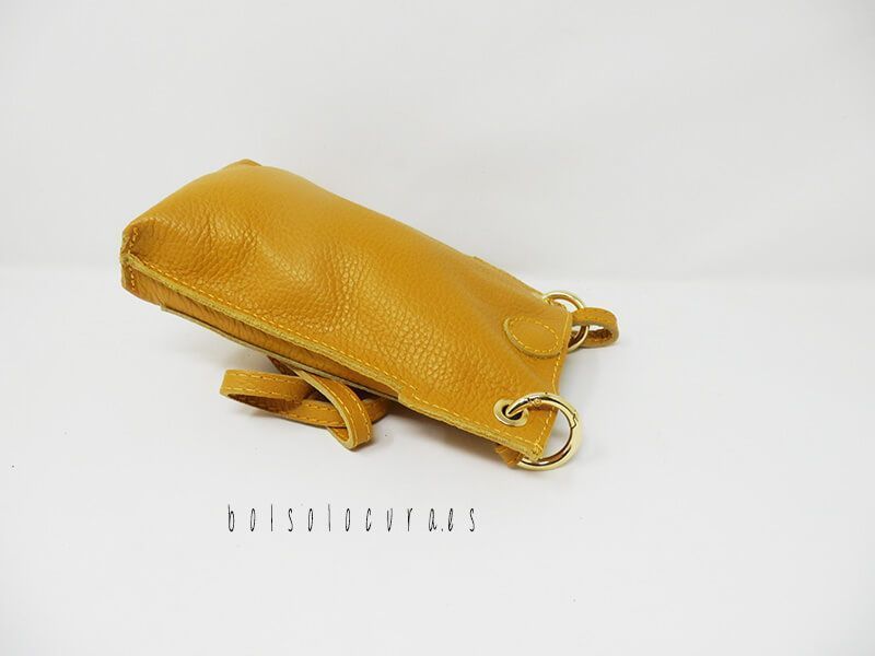 Un modelo de bolso y bandolera portamóvil de piel en color mostaza