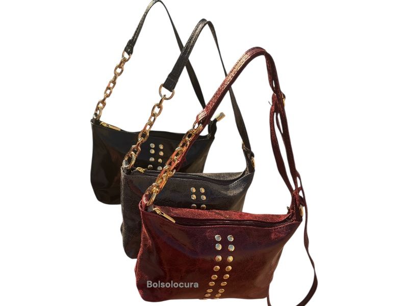 Bolsos y Bandoleras tachuelas Piel brillo. Asa con adorno cadena y dos bolsillos para el teléfono.